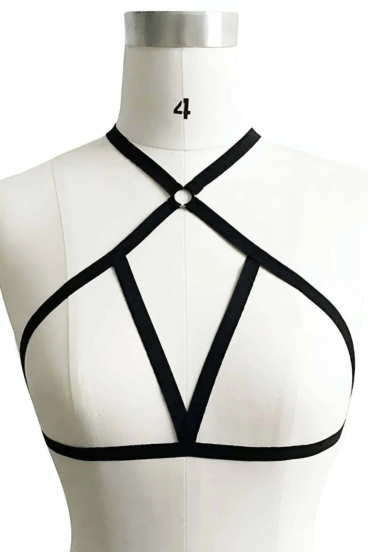 siyah spandex göğüs harness'ı gümüş O-halkada kesişen beş askı koyu kıyafetin üstünde önden yakın çekim