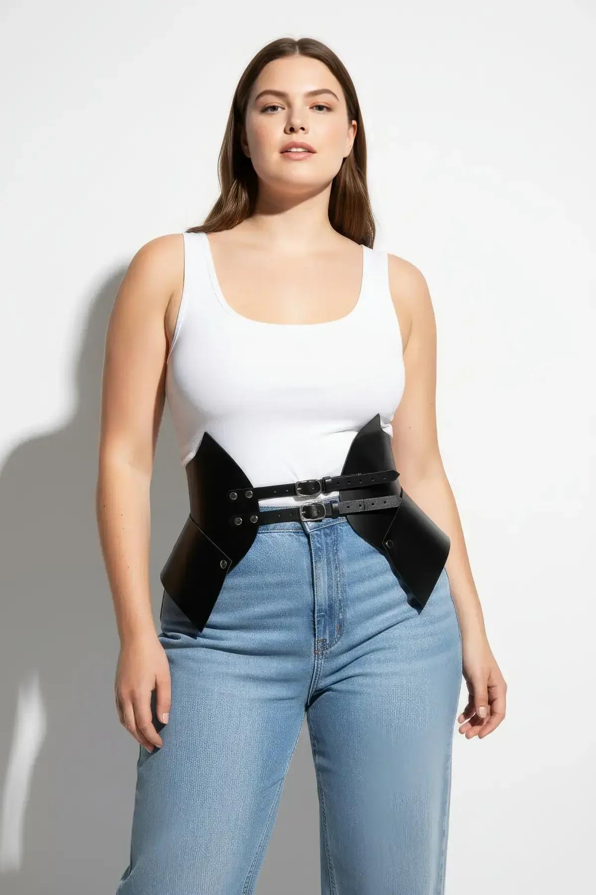 Dışarıda beyaz dar üst ve bol paçalı denim jean üzerine stilize siyah suni deri bel sıkıştırıcı harness