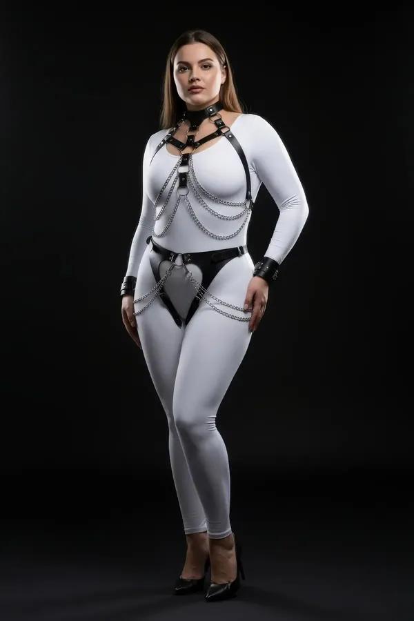 Dökümlü gümüş zincirler, çoker boyunluk, kalça paneli ve bilek manşetleriyle siyah suni deri tam vücut harness, beyaz üzerinde