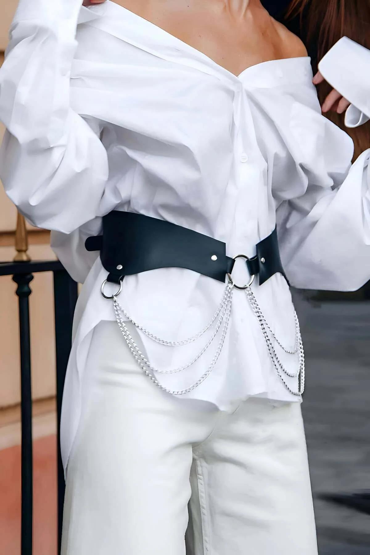 Siyah geniş bel harness kemeri üzerinde gümüş O-halka ve perçin detayı, yakın çekim