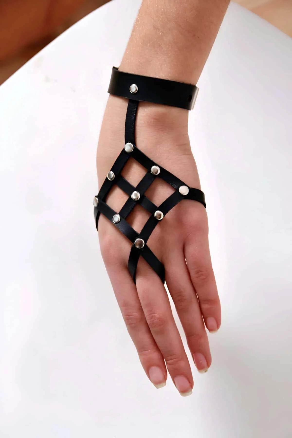 Zımbalı ızgara el harness üzerinde çıtçıtlı geniş siyah bilek manşeti, yakın detay