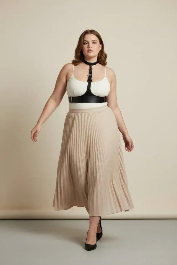 Beyaz bodysuit ve bej pileli etek üzerinde gümüş tokalı siyah suni deri çoker göğüs altı harness