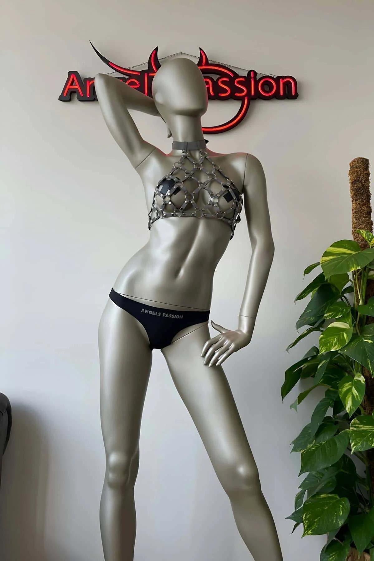 Karanlık arka planda çıplak deri üzerine giyilen, açık halka kafes boşluğu desenli zincir posta halter harness