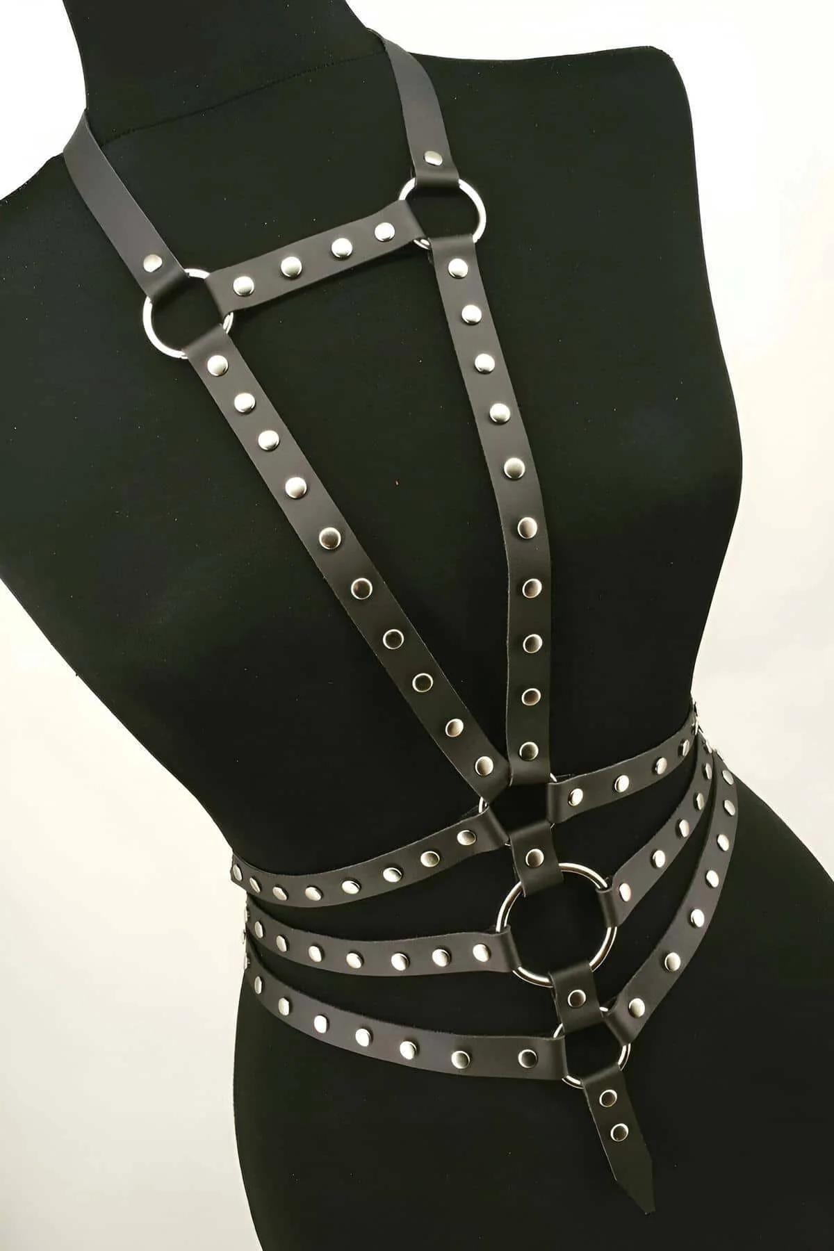 Siyah mini etek üzerinde katmanlı zımbalı suni deri harness tam gövde kapsama ve strap düzeni