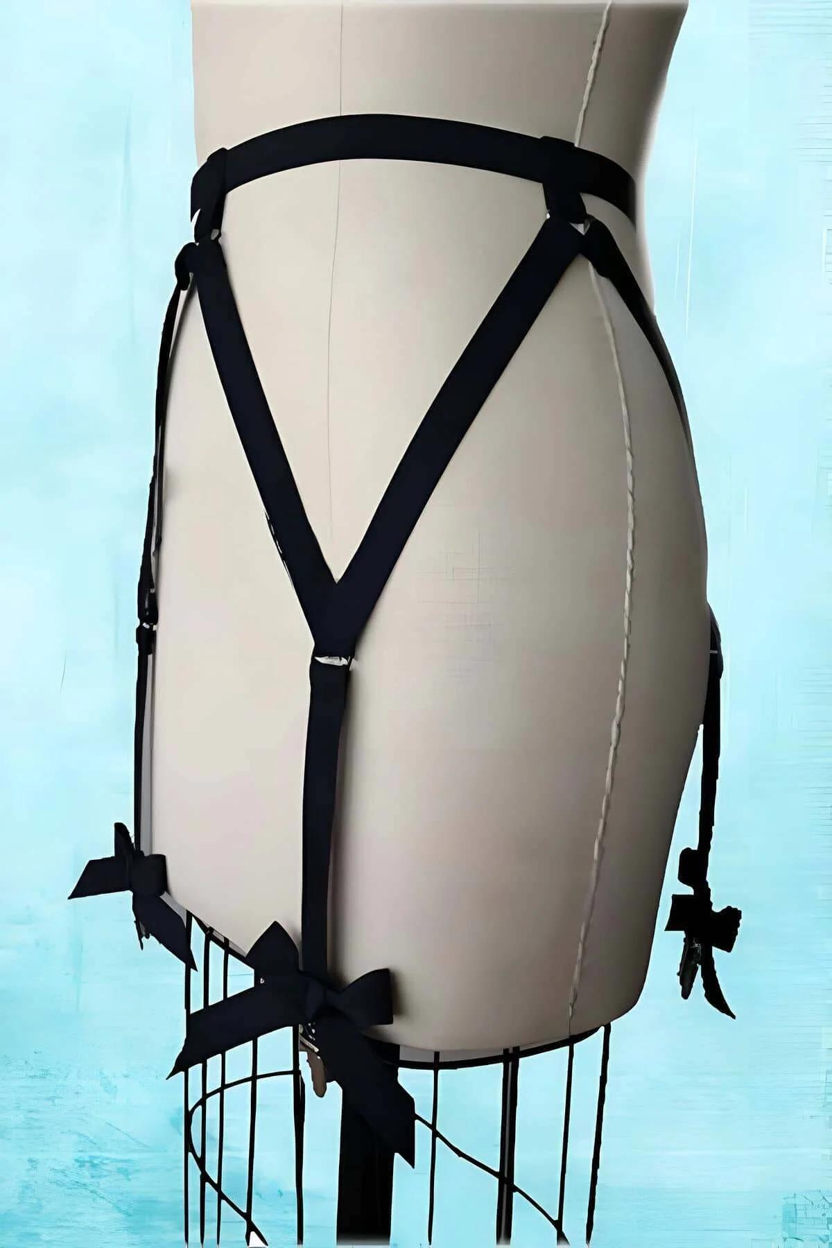 Jartiyer harness bacak askısındaki gümüş metal jartiyer tokasıyla siyah saten kurdele yakın çekim