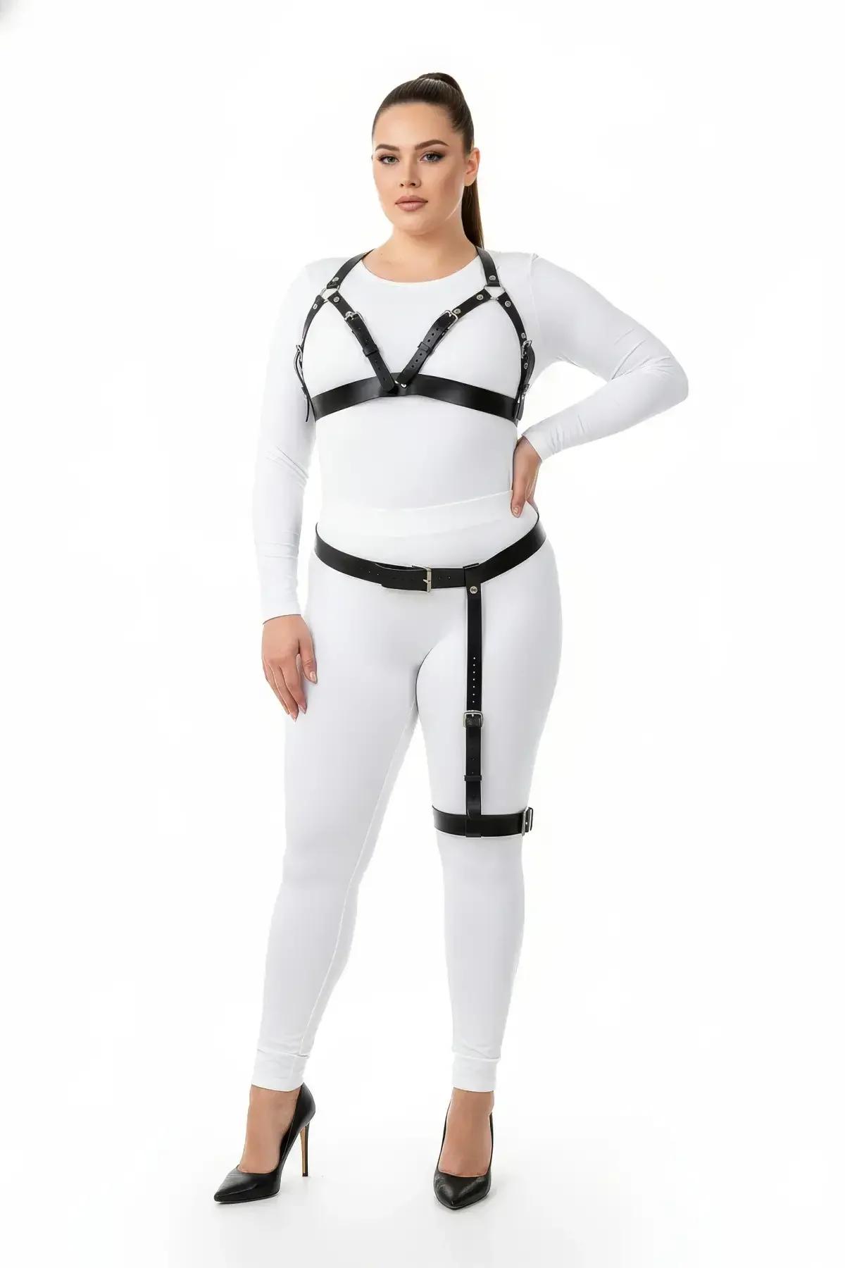 Gümüş toka donanımlı siyah suni deri harness sütyen ve uyluk jartiyer seti, beyaz bodysuit üzerinde