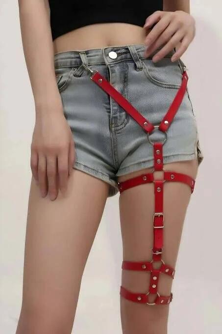 Kırmızı suni deri uyluk harness gümüş iğne tokalar ve delik detayı, yakın çekim