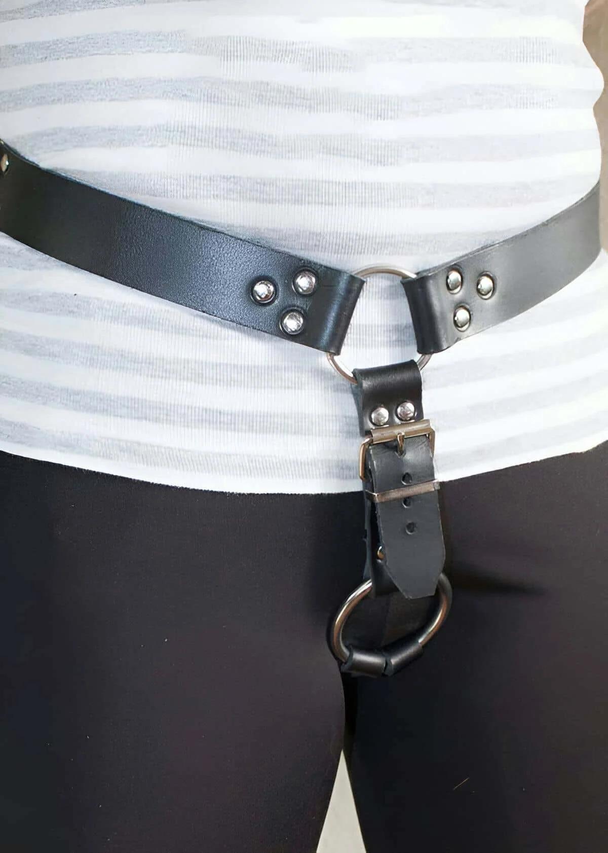 Siyah suni deri bel harness askısındaki gümüş O-halka ve kubbeli perçinler yakın çekim