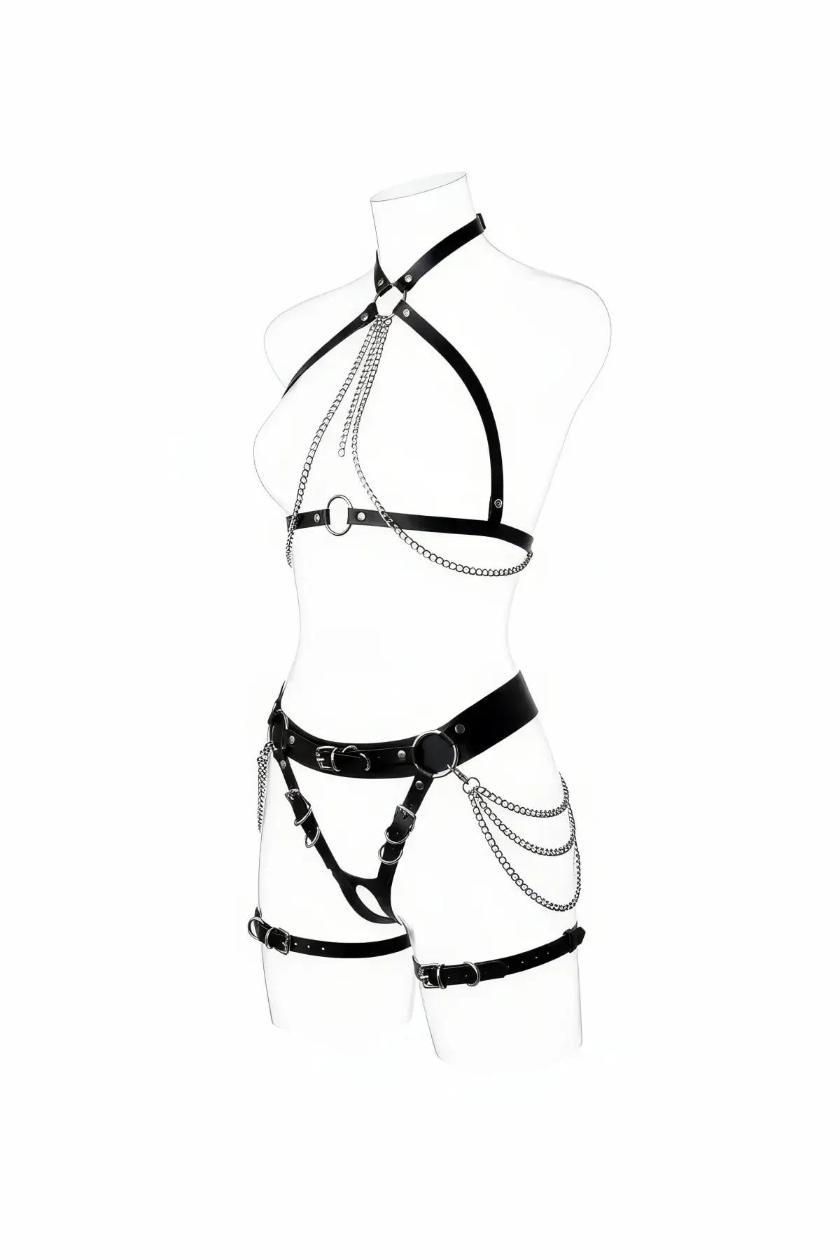 Beyaz manken üzerinde katmanlı gümüş zincir göğüs dökümlü ve asimetrik uyluk bantlı siyah suni deri tam vücut harness