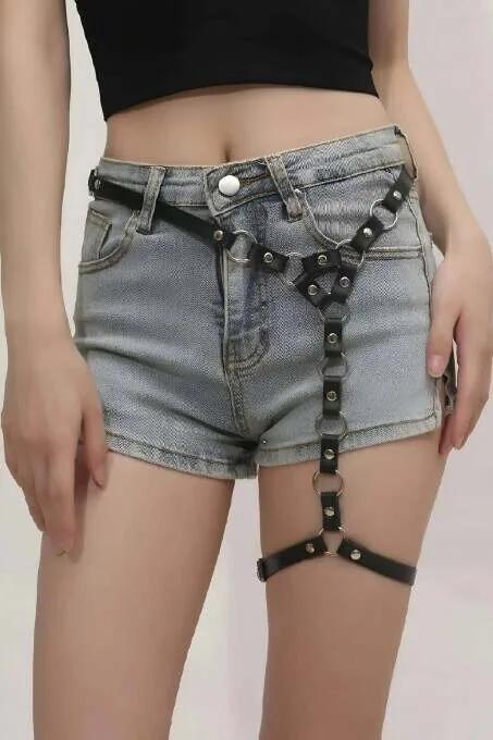 Denim şort üzerine giyilen gümüş O-halkalar perçinler ve çıkarılabilir zincirli siyah suni deri tek bacak jartiyer harness