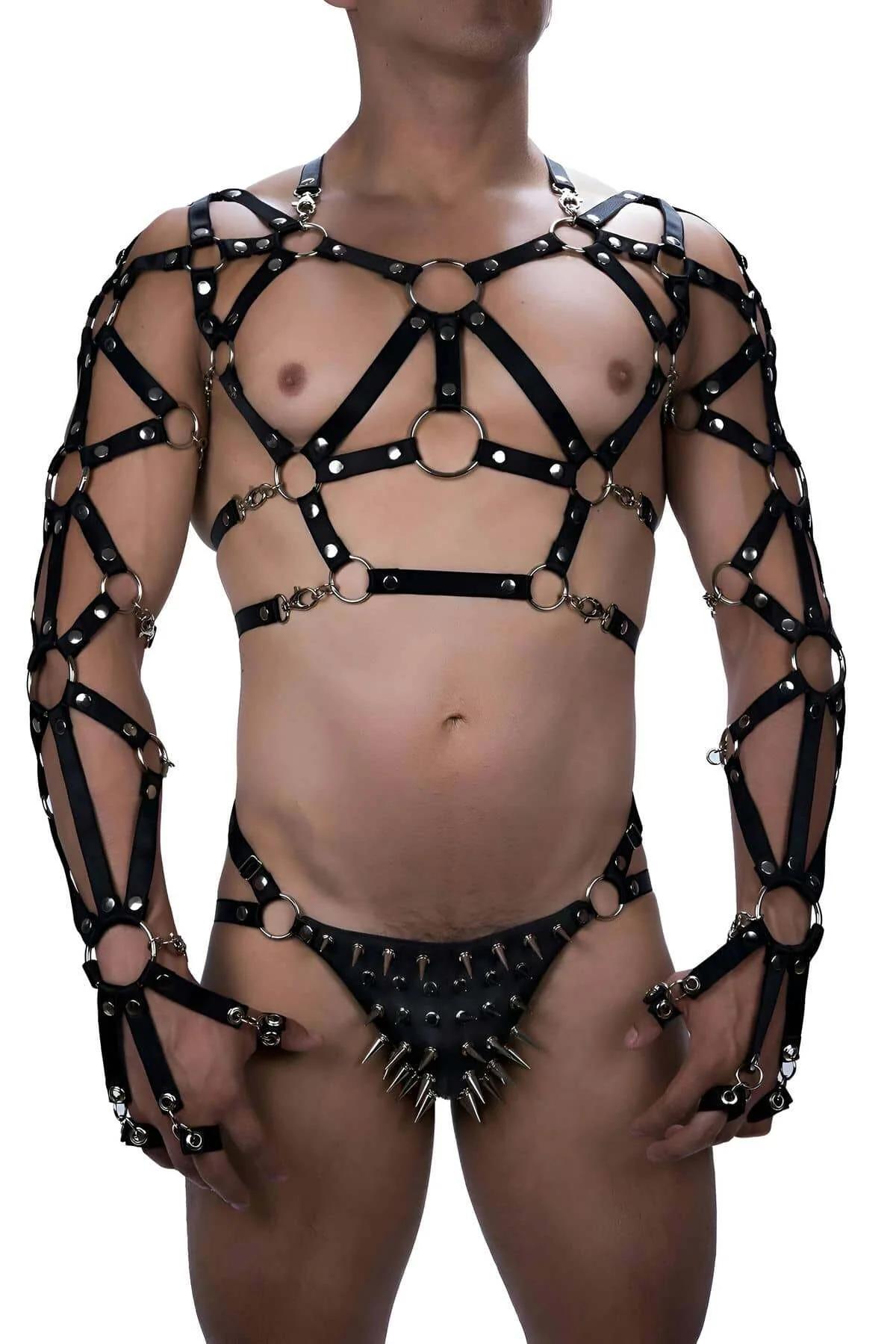 Gümüş O-halkalar, kafes kol kılıfları ve çıkarılabilir sivri uçlu tanga içeren siyah suni deri tam vücut harness'ı ön görünüm